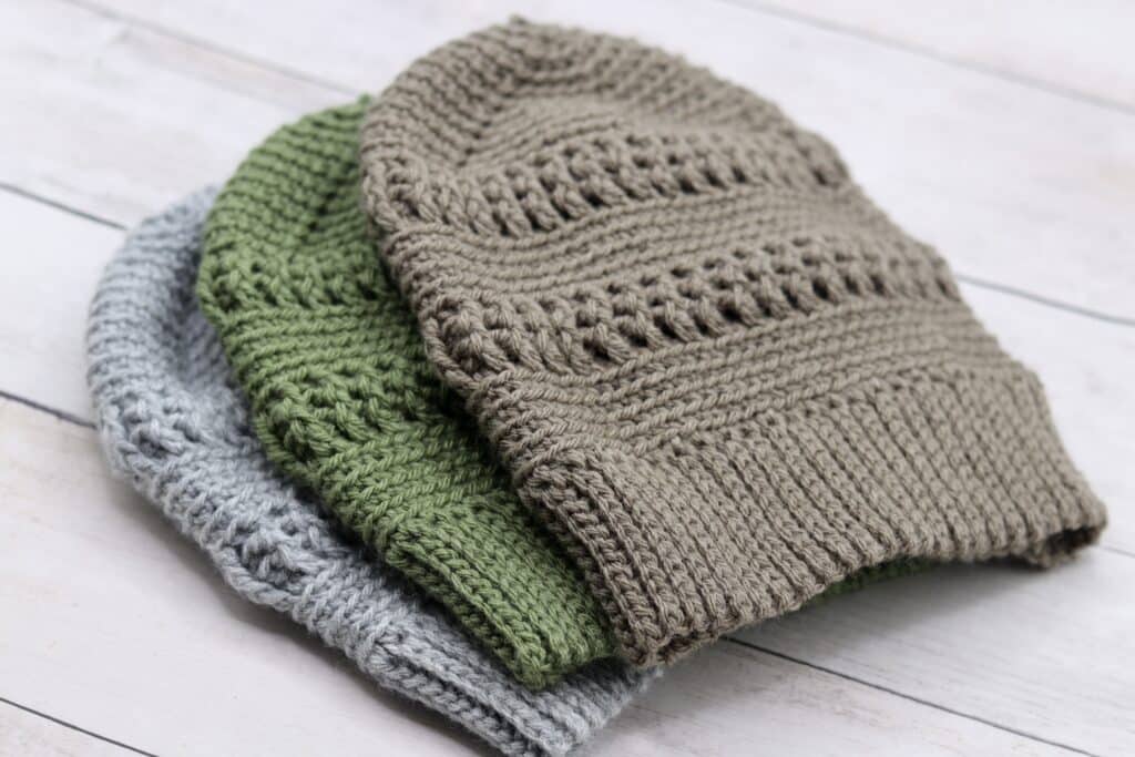 A sweet of three textured crochet beanies in grey, green and tan coloured yarn