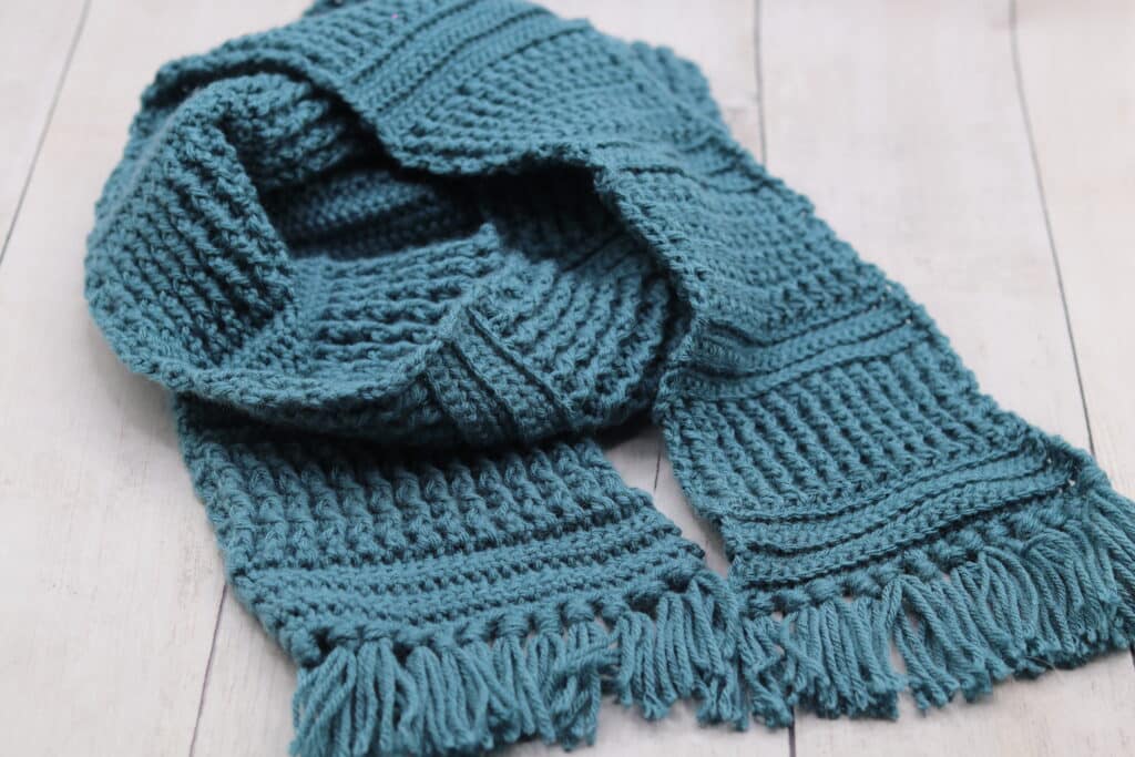 The crochet Windermere scarf worked in a teal coloured yarn