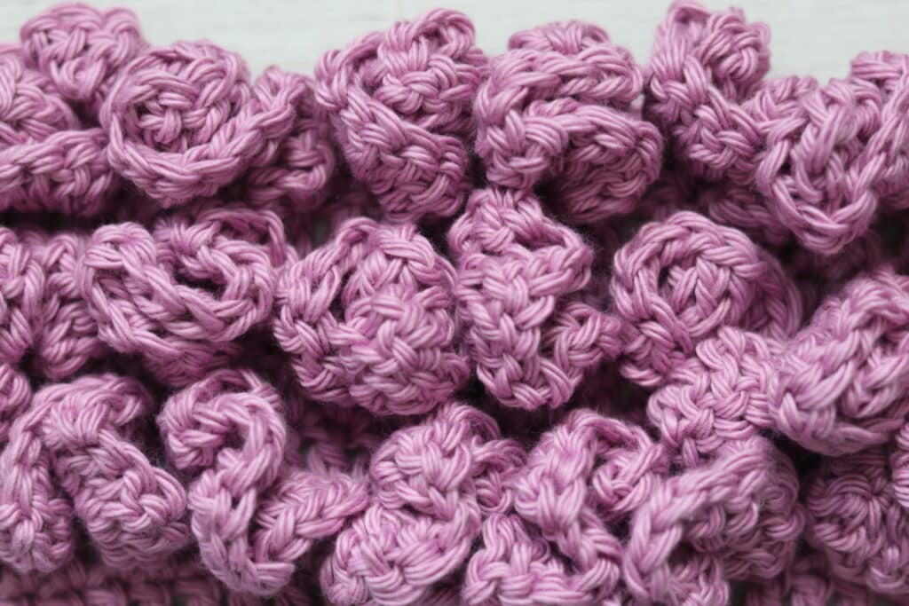 A swatch of the crochet ruffle stitch worked in pink yarn