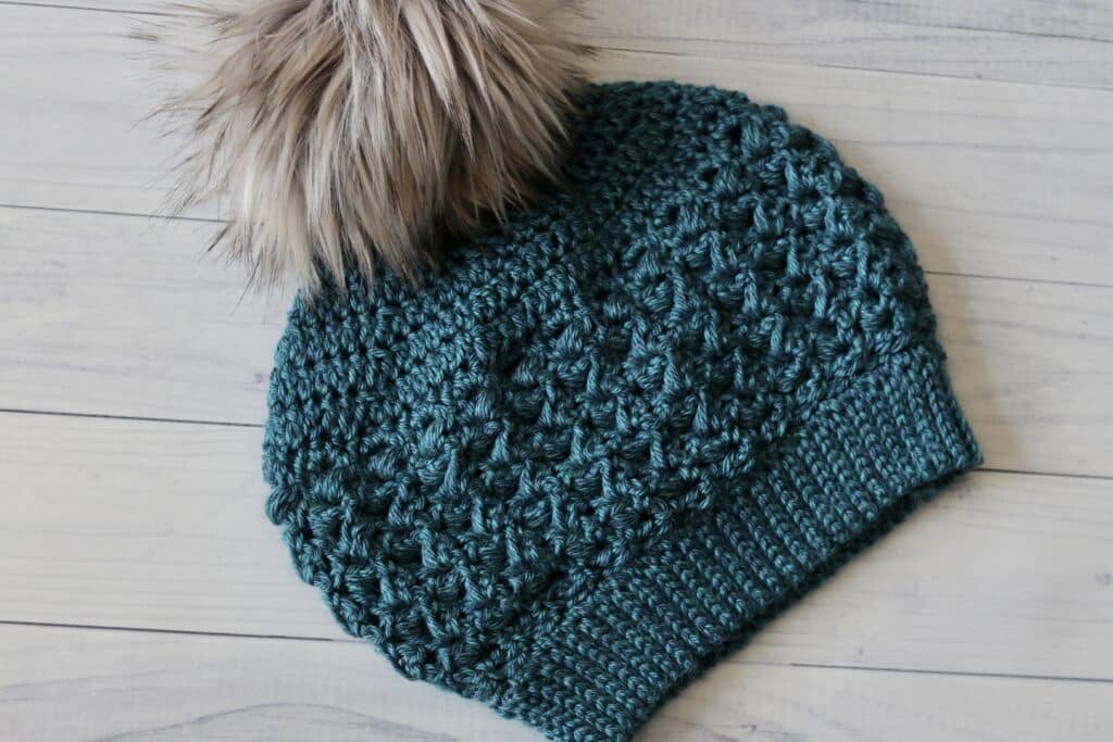 The Little Rock Crochet Slouch Hat shown with a pompom
