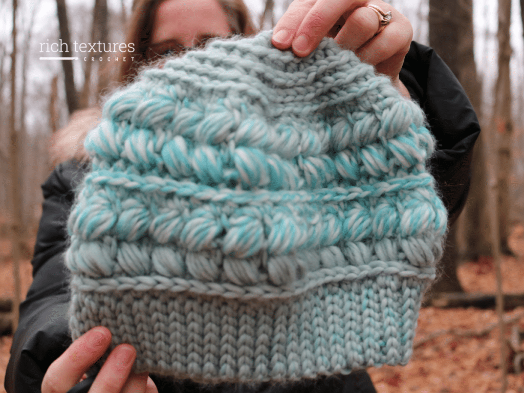 A crochet beanie featuring braided puff stitches