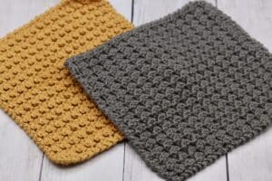 two crochet dishcloths in yellow and grey yarn