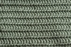 A swatch of the crochet Treads Stitch worked in a green coloured yarn