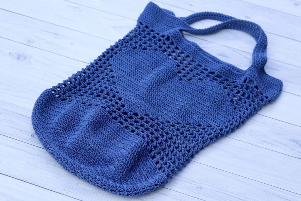 blue crochet market bag featuring a heart on the front