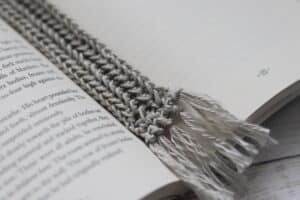 A close up of the crochet summer bookmark in grey yarn
