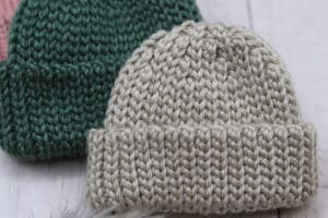 Two crochet hats for children. One white, one green.