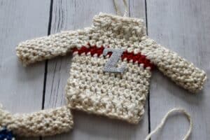 A little Christmas Sweater ornament with a red stripe