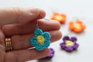 Hand holding a single crochet flower earring