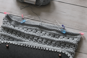 From the side markers, count in 13 stitches toward the centre on the front and back and mark those stitches