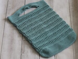 A green crochet market bag with a lot of texture