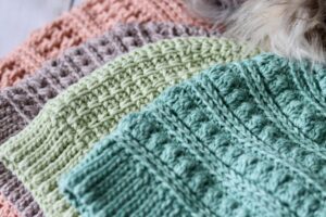 A close up of the sides of four crochet hats