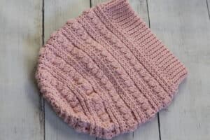 A pink crochet hat with no pompom.