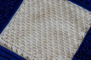 A close up of the raised diagonal blanket square in white yarn