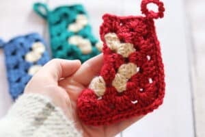 A mini Christmas Stocking worked from a granny square held in a hand
