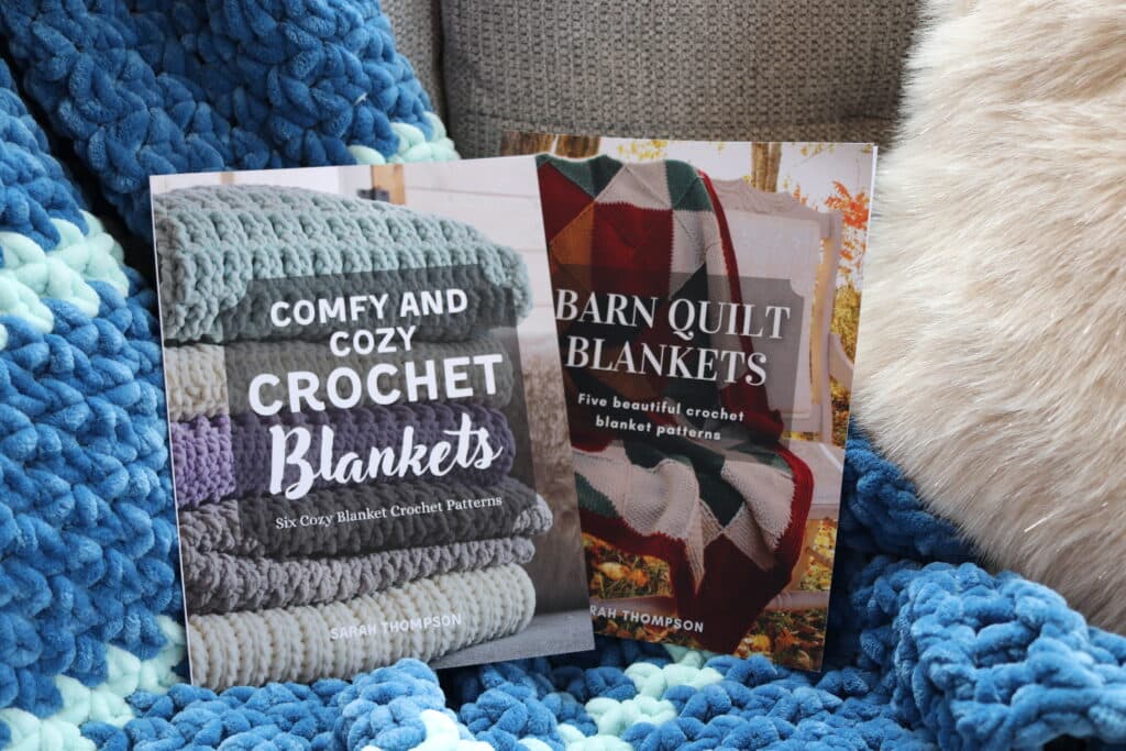 Barn Quilt Blankets and Comfy and Cozy Crochet Blanket books displayed on a couch with a blue striped blanket