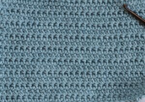 A swatch of the extended single crochet stitch worked in blue yarn