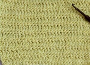 A swatch of the standing chain crochet stitch worked in yellow yarn