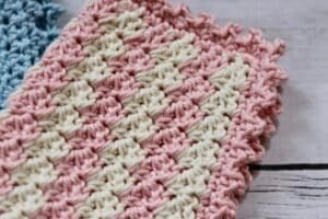 A close up of the picot edging on a pink and white crochet dishcloth