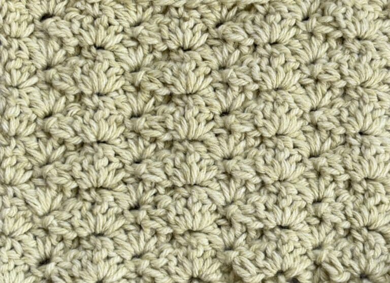 A swatch of the closed shell crochet stitch pattern worked in a light green yarn
