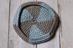 The underside of a crochet flying disc in grey and blue yarn
