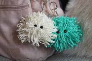 Two crochet keychains hanging on a backpack