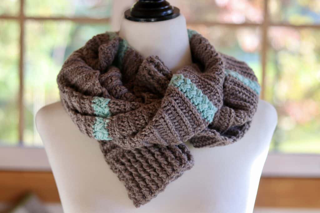 A crochet scarf wrapped around a mannequin