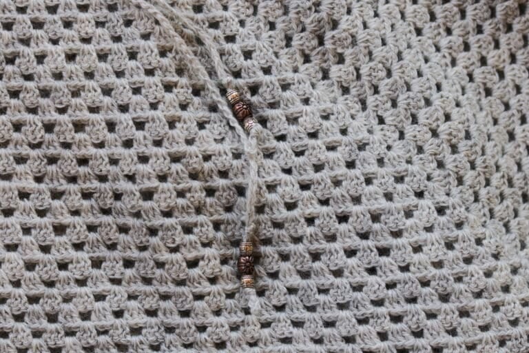 A Close up of the stitches and beads in the Silver Lining Poncho crochet pattern